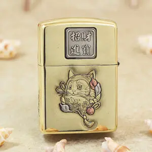 Gold metal lighter with Chinese characters on the top and a carved cat surrounded by flowers on the front (decorative engraving).