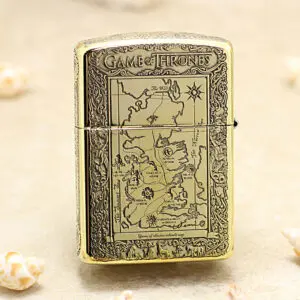 Gold-toned lighter engraved with a Game of Thrones map design on the front, ornate border surrounding the map.