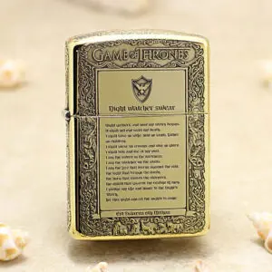 Gold-toned lighter engraved with Game of Thrones motifs and 'Night watcher swear' text on a parchment panel