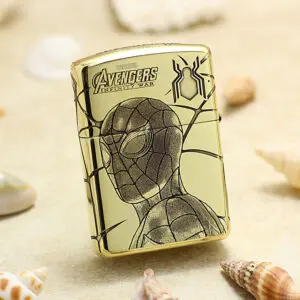 Gold metal lighter featuring Spider-Man drawing and Avengers: Infinity War logo on a sandy beach background.