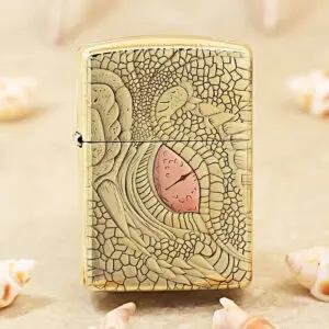 Gold Zippo lighter with a cracked, lace-like engraving and a pink teardrop centerpiece.