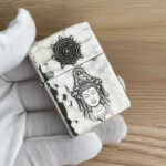 Guanyin and Dharma wheel relief on the sterling silver Zippo Armor lighter