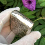 Polished top edge of the Varga Girl arabesque sterling silver Zippo Armor lighter