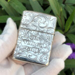 Hand-held reverse view with 1933 Varga Girl lettering and dense arabesque scrollwork
