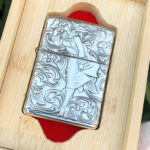 Front view of the Varga Girl arabesque sterling silver Zippo Armor lighter in wooden display box