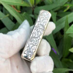 Side view of continuous arabesque engraving on the sterling silver Zippo Armor lighter