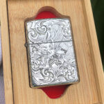 Dragon and phoenix sterling silver Zippo Armor lighter displayed in a wooden presentation box
