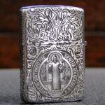 Front view of sterling silver Zippo with St. Benedict figure and ornamental engraving