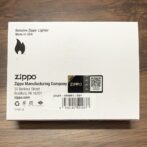 White Zippo lighter box on a wooden surface, showing the Genuine Zippo Lighter label and barcode.