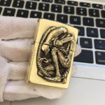 H.R. Giger Alien Anniversary high-polish brass Zippo lighter front view