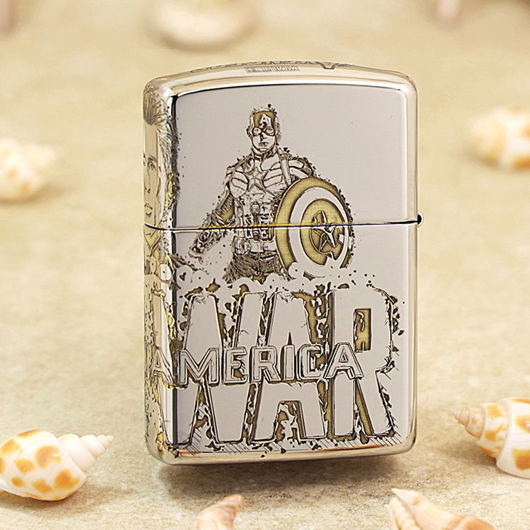 Metal lighter featuring Captain America illustration and shield, with bold 'AMERICA' lettering on a sandy surface with seashells nearby