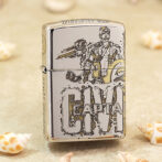 Shiny Zippo lighter featuring a Captain America illustration and logo, resting on sandy surface with seashells nearby.
