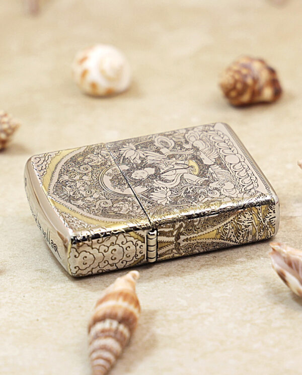 KZ144-04 Ornate silver lighter with detailed floral engravings, surrounded by seashells on sandy surface.