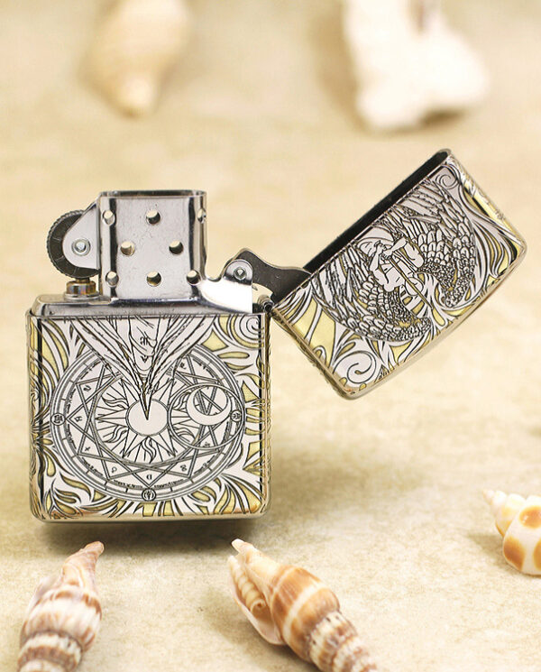 KZ145-03 Metal lighter with intricate engraved designs (geometric and dragon motifs) on a sandy surface, lid open.