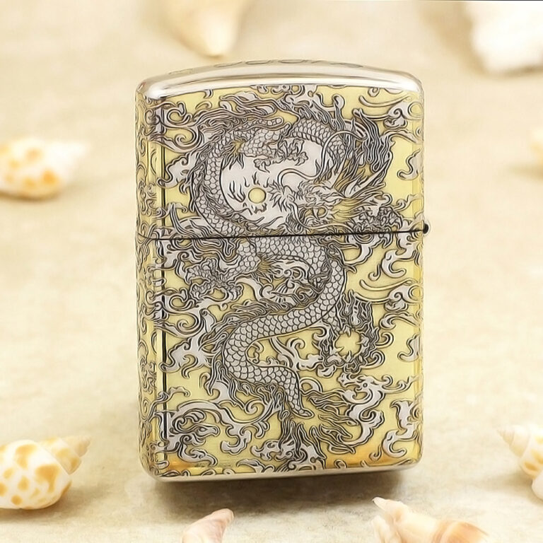 Metal lighter with an intricate dragon engraving in dark lines on a gold-tone surface.