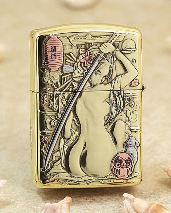 Gold Zippo lighter with an Asian-inspired engraving of a woman holding a sword, surrounded by flowers and a pink lantern.