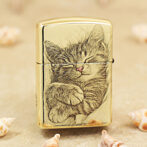 Gold Zippo lighter with a sleeping kitten illustration on the front.