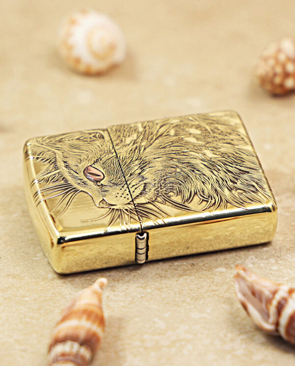 KZ152-04 Gold engraved lighter with a dragon design on a sandy surface, surrounded by seashells.