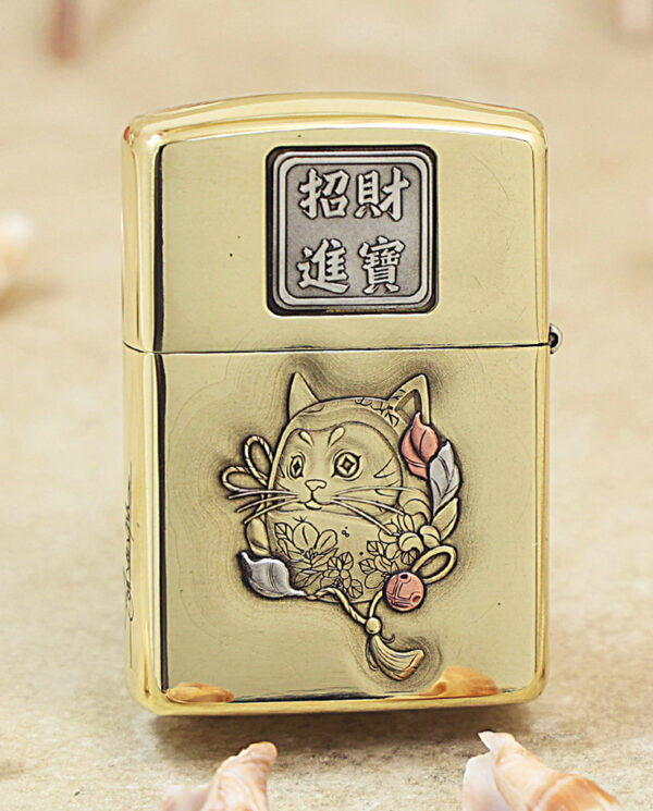 Gold metal lighter with Chinese characters on the top and a carved cat surrounded by flowers on the front (decorative engraving).