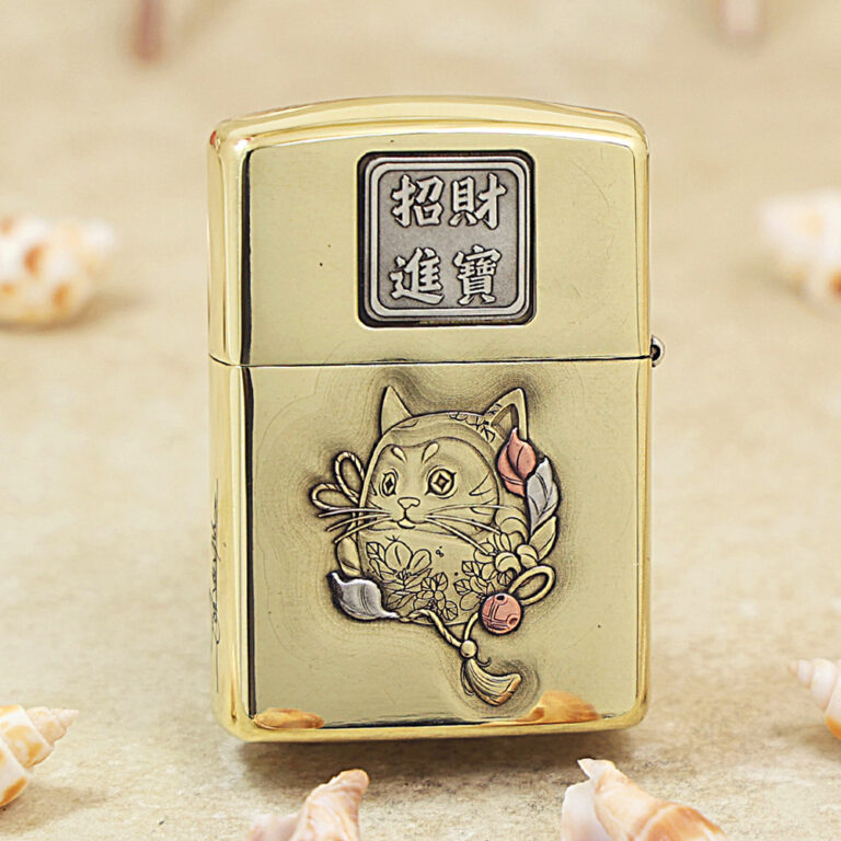 Gold metal lighter with Chinese characters on the top and a carved cat surrounded by flowers on the front (decorative engraving).