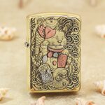 Ornate Maneki-neko lucky cat engraved on brass Zippo Armor lighter with pink accents