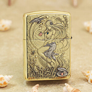 Gold Zippo lighter with a high-relief mermaid underwater scene and seashells engraving on brass surface.