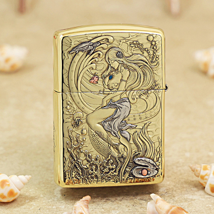 Gold Zippo lighter with a high-relief mermaid underwater scene and seashells engraving on brass surface.