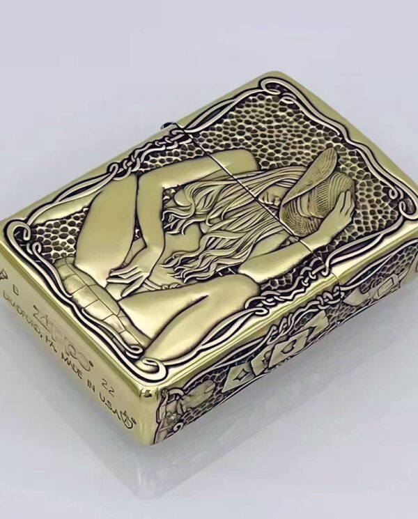 KZ157-01 Gold-toned lighter with an Art Nouveau engraving of a reclining woman holding a hat, surrounded by ornate borders and lattice background.