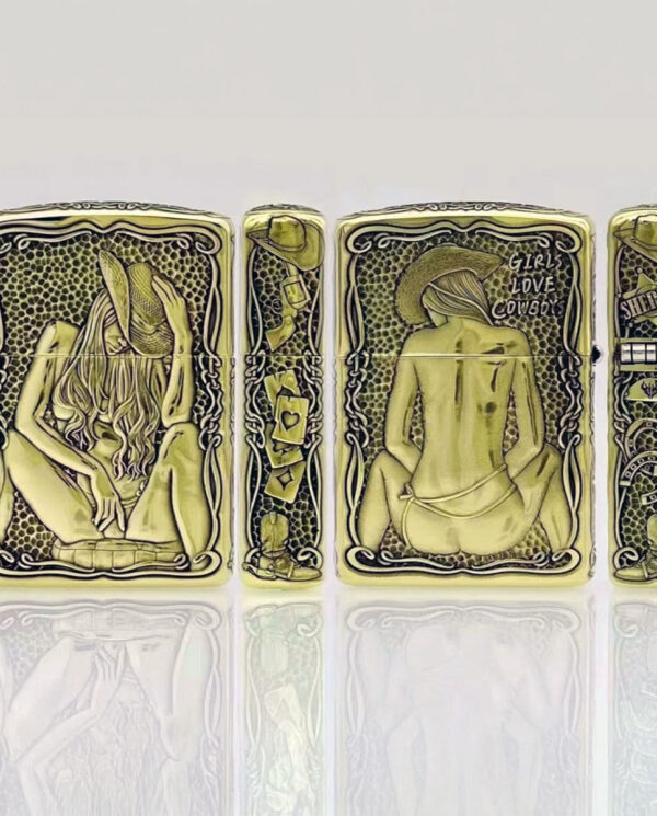 KZ157-05 Four gold-toned lighters in a row with intricate black pin-up/western artwork and decorative borders; reflective surface below.