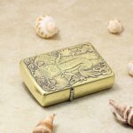 Two-sided elephant engraved brass Zippo Armor lighter lying flat