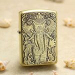 Majestic tusked elephant engraved on the front of antique brass Zippo Armor lighter