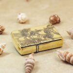Rose lady figure engraved Zippo Armor lighter lying flat among seashells