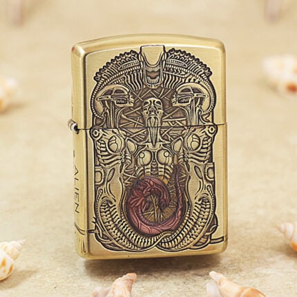 Biomechanical alien engraving with red-brown accent on brass Zippo Armor lighter, front view