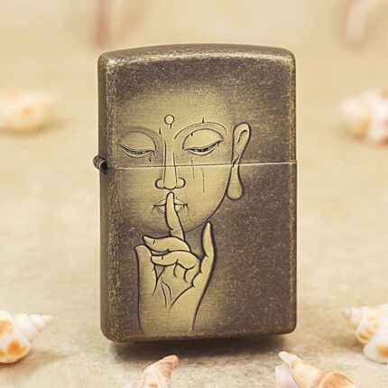 Antique brass Zippo lighter engraved with a Buddha face and silence hand gesture