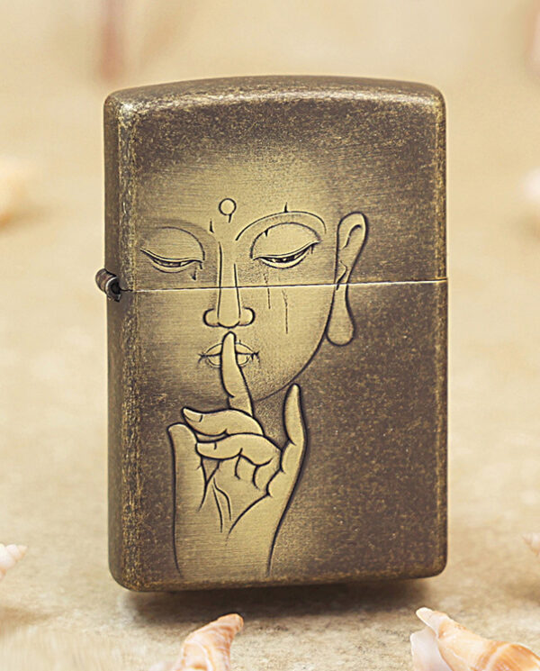 KZ179 Bronze metal lighter with a line drawing of a person holding a finger to their lips, signaling 'shh', on a sandy surface with seashells nearby.