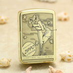 Vintage Zippo lighter standing upright on sandy surface with a retro engraving of a woman blowing a kiss; windproof design.