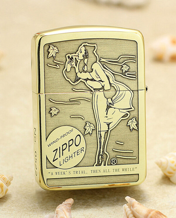 KZ183-01 Vintage Zippo lighter standing upright on sandy surface with a retro engraving of a woman blowing a kiss; windproof design.