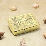 Vintage Windy Zippo 1941 Replica lighter lying flat among seashells