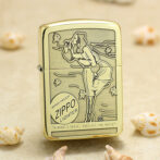 Gold-tone Zippo lighter with an engraved seaside scene, featuring a woman by the wind-swept ocean and the words 'Zippo Lighter' on the case.
