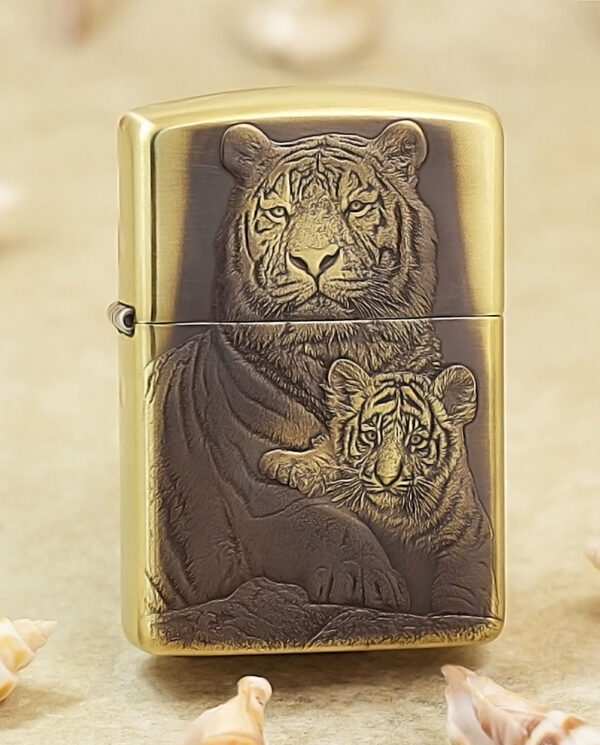 KZ184 Gold Zippo lighter with a carved image of a tiger and cub on the front.