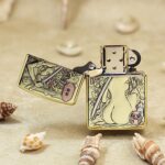 Open brass Zippo Armor lighter showing katana woman artwork across the body and lid