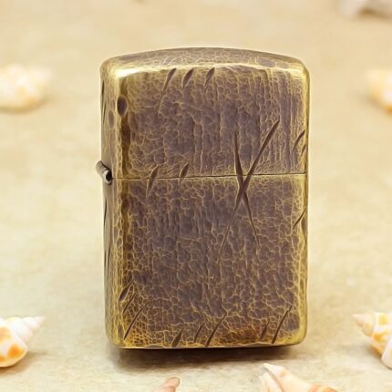 Antique brass Zippo Armor lighter with cracked leather texture and diagonal knife marks, front view