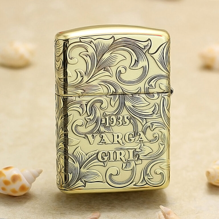 Gold-tone lighter with intricate scrollwork engraving reading '1935 VARGA GIRL'.