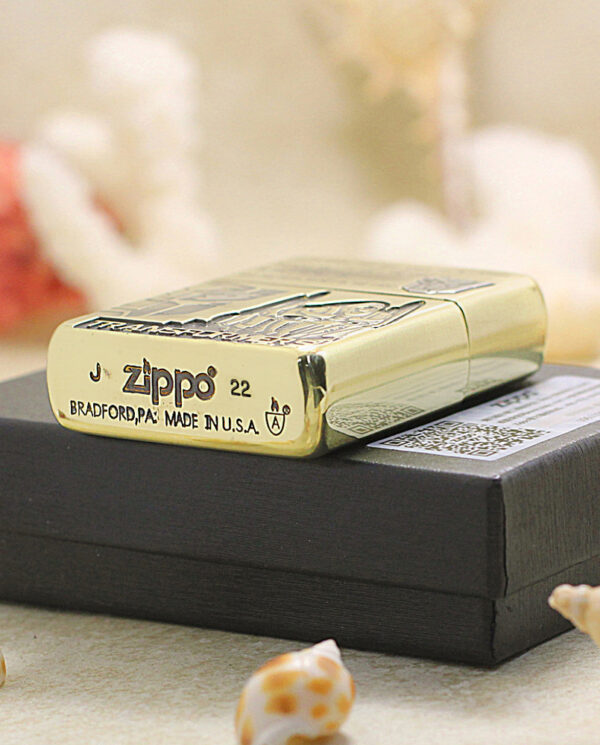 KZ206-05 Gold Zippo lighter resting on a black box, with 'Bradford, PA Made in U.S.A.' engraved on the base.