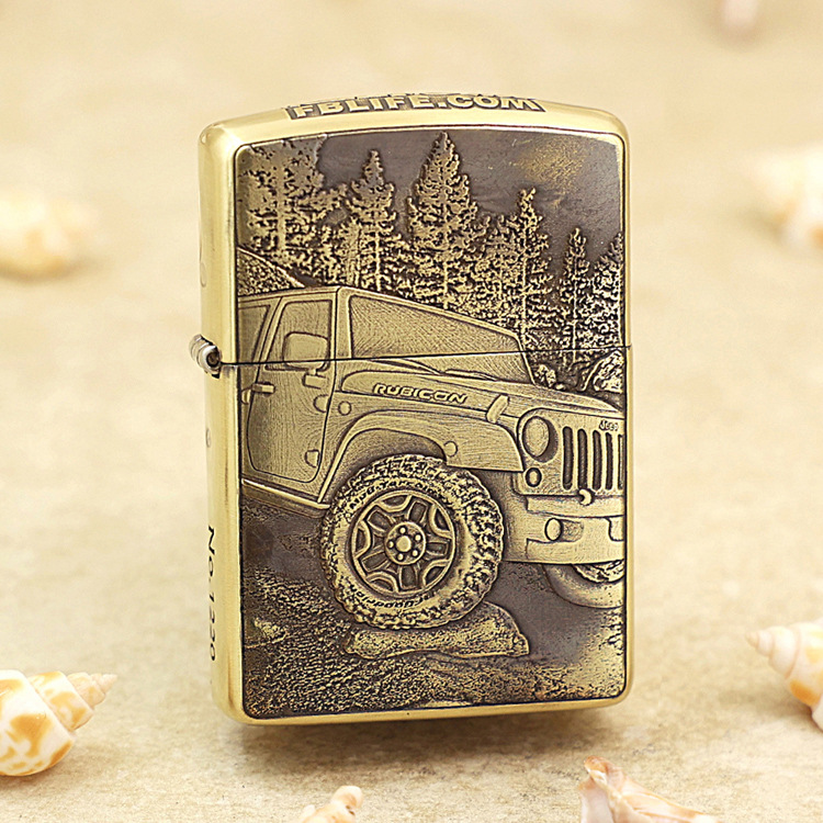 Gold-toned lighter with a detailed engraving of a Jeep Rubicon off-road vehicle and a forest backdrop on its front face.