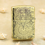 Gold engraved Zippo lighter with an angel wings design above a circular geometric seal from the engraving on the front surface.