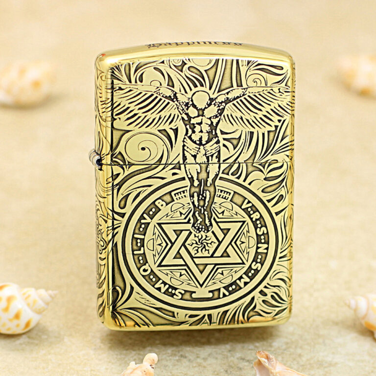 Gold-tone Zippo lighter with black engraving of a winged figure above a circular mystical symbol with a six-pointed star.