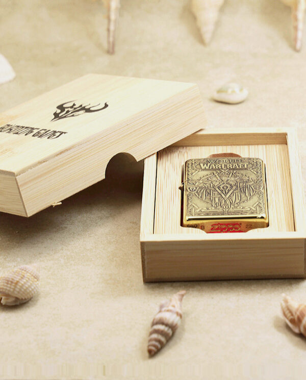 KZ217-06 World of Warcraft themed Zippo-style lighter in a wooden presentation box, on a sandy surface with shells