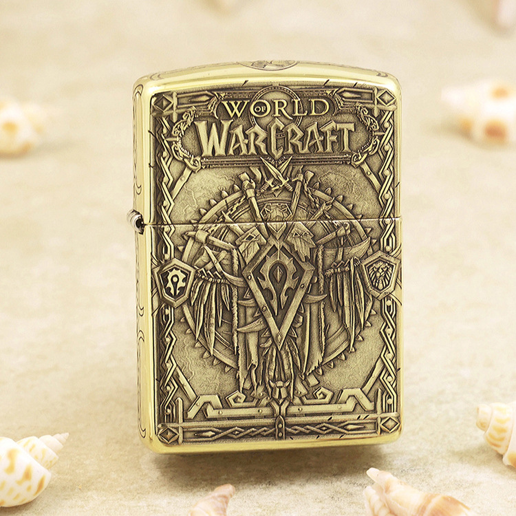Gold-toned Zippo-style lighter with embossed World of Warcraft artwork and ornate fantasy armor motif, including the game logo at the top