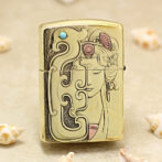 Gold-toned Zippo-style lighter with an Art Nouveau design featuring a woman's face and swirling patterns.